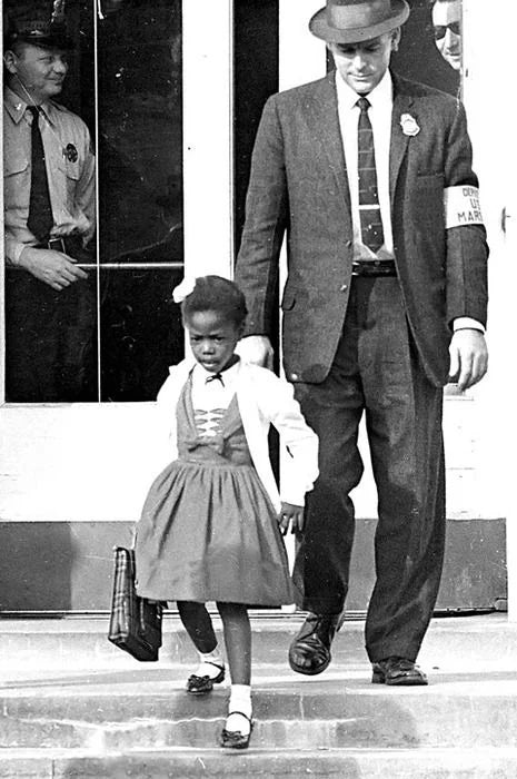 Six-year-old Ruby Bridges walks down the school steps escorted by U.S. Deputy Marshals, New Orleans, 1960